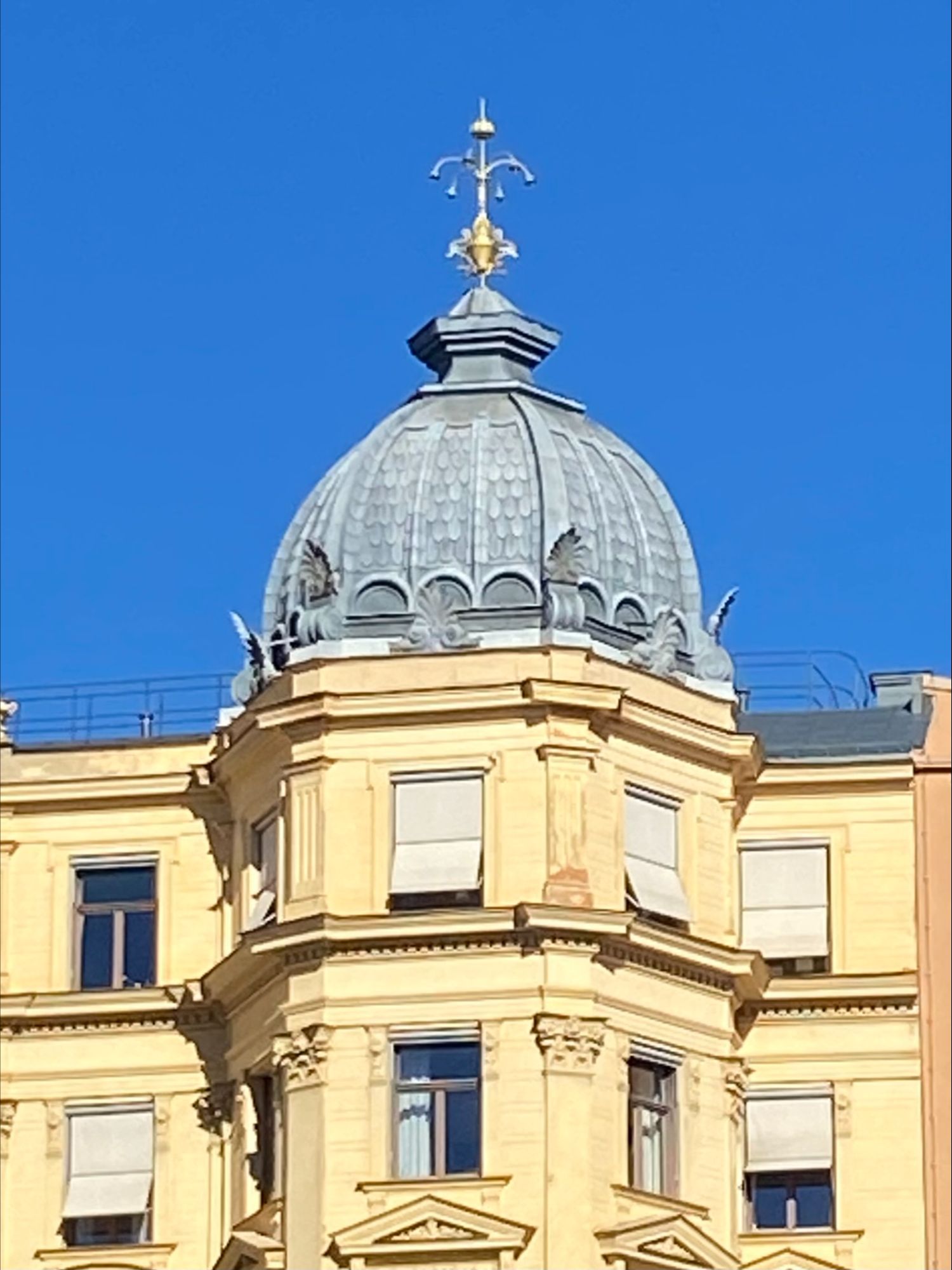 Historic Stockholm building with ornate stone façade, rounded corner balconies, and a tall tower topped by a green copper cupola.
