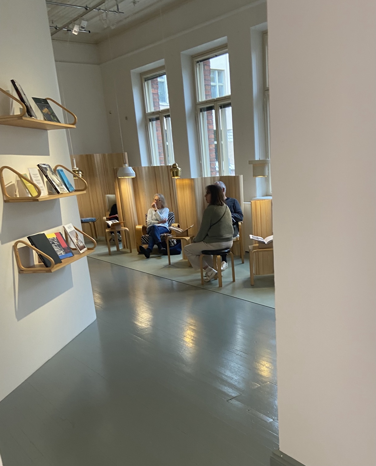 Visitors seated among Alvar Aalto furniture in the Architecture and Design Museum lounge