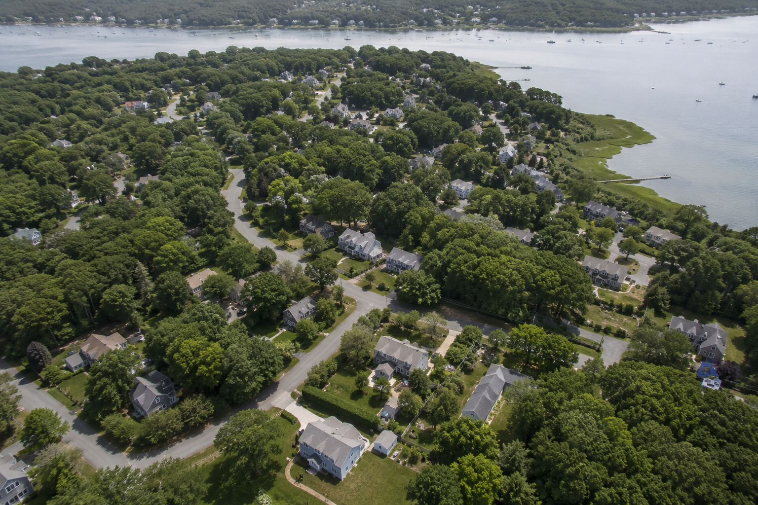 Aerial view of a Cape Cod neighborhood near Barnstable Harbor showing residential lots with septic system setback zones visible from above