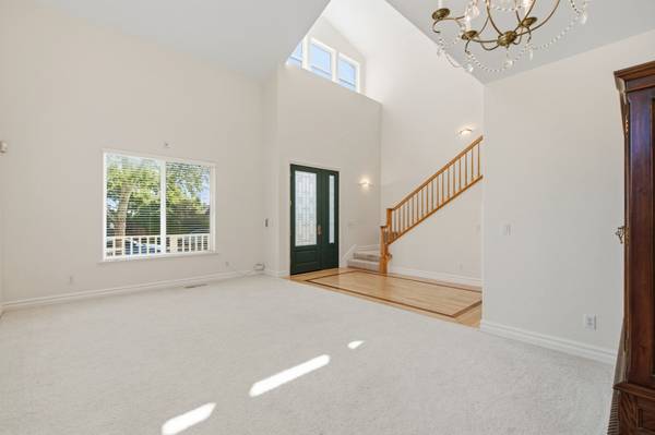 Light-filled living room with two-story ceilings and large windows in Cambrian home