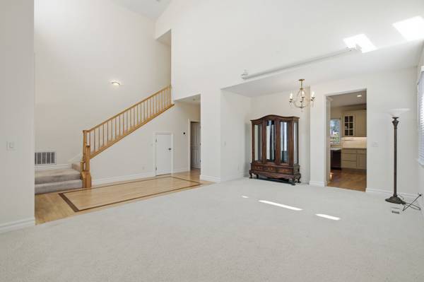 Light-filled living room with two-story ceilings and large windows in Cambrian home