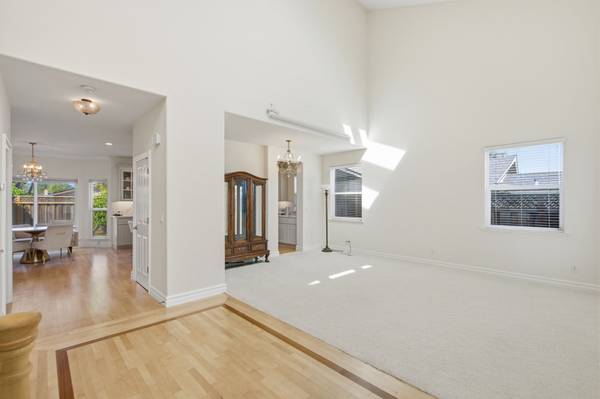 Light-filled living room with two-story ceilings and large windows in Cambrian home