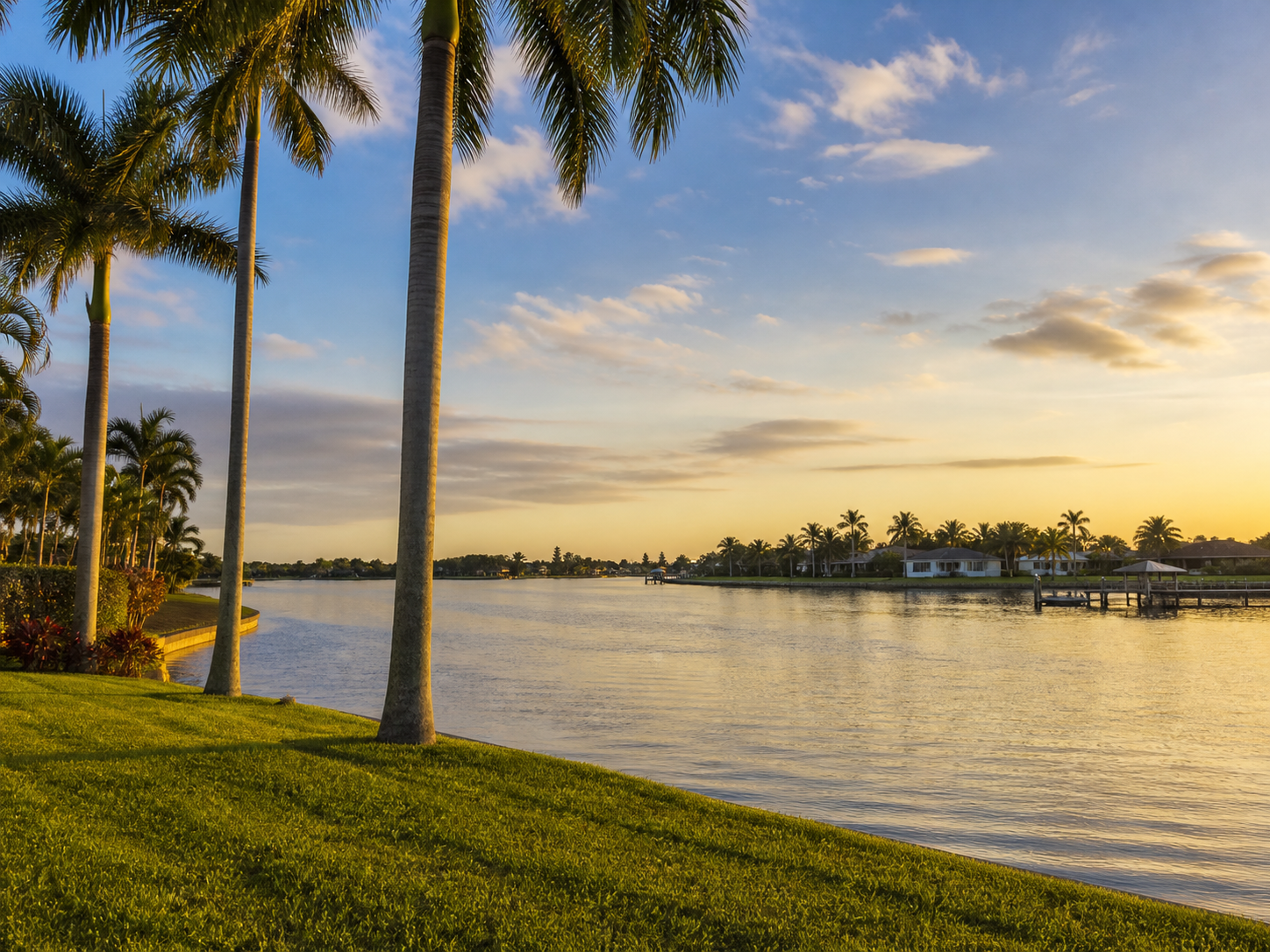 The Caloosahatchee River at sunset seen from a palm-lined bank in North Fort Myers, Florida