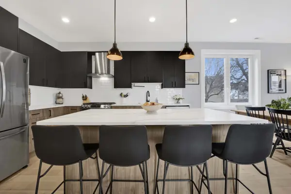 Logan Square penthouse for sale — open kitchen with quartz island and soaring ceilings at 1932 N Drake Ave