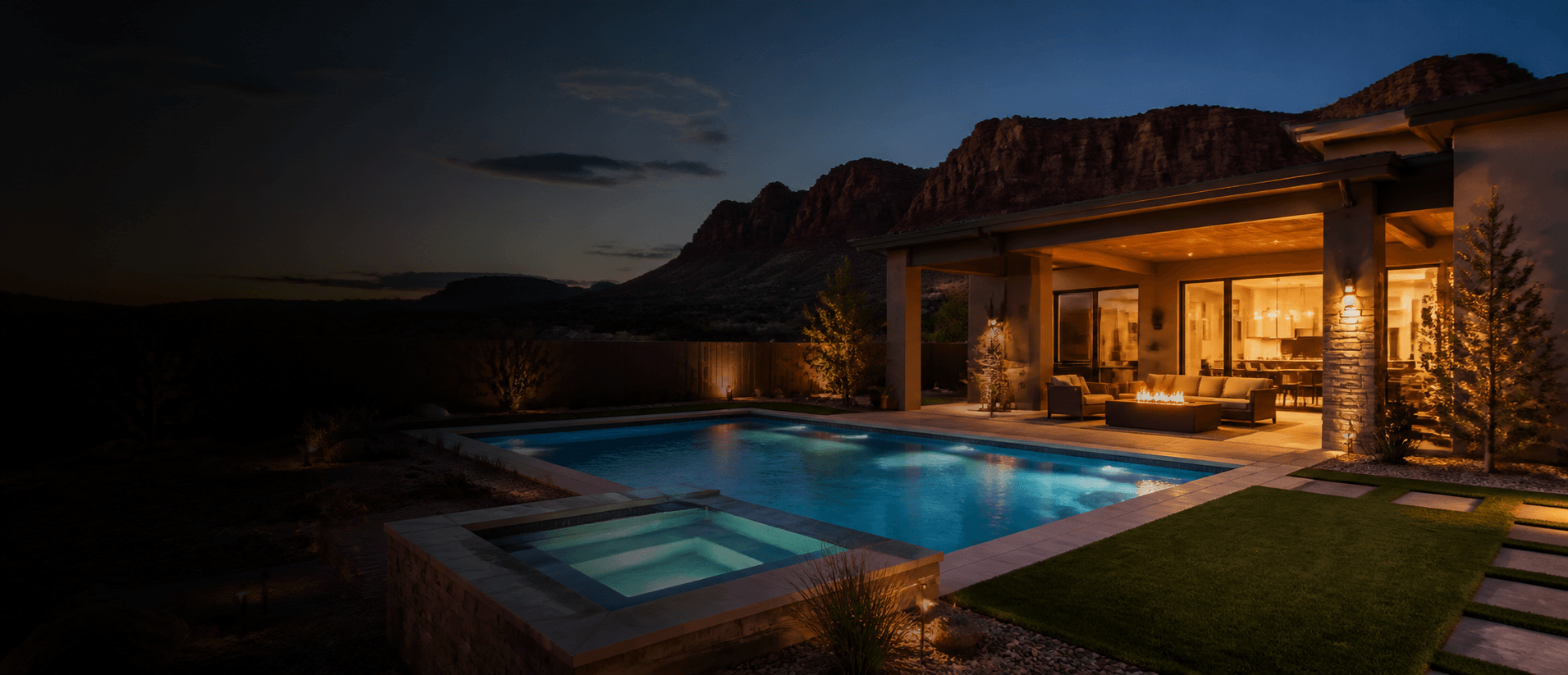 Lit pool and patio of a nightly rental home in St. George, Utah at dusk