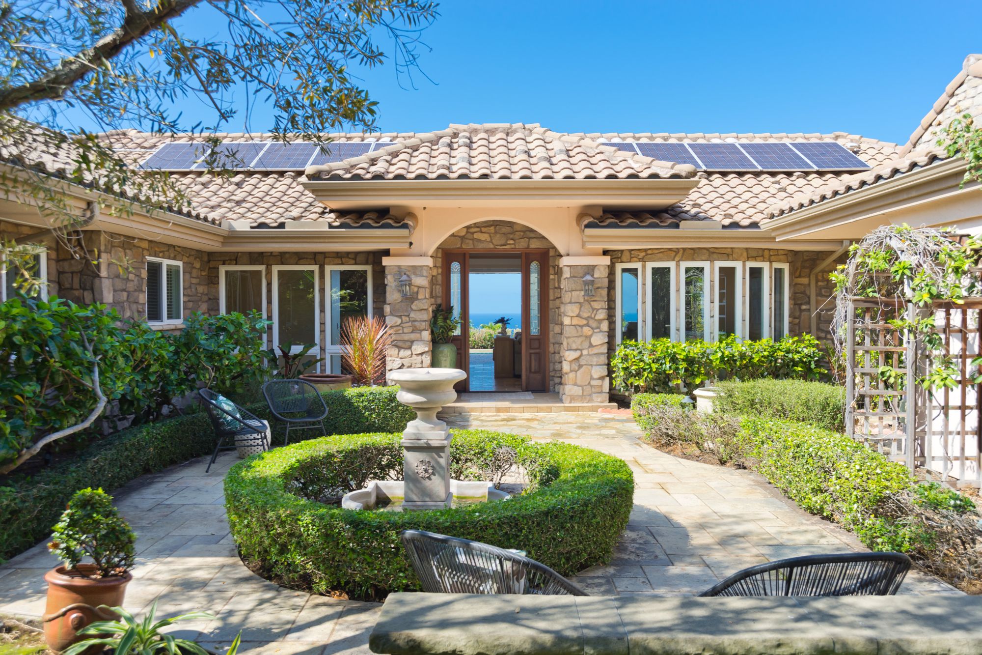 Entry view showing the arched doorway and courtyard at 78-7043 Mololani St in Bayview Estates.
