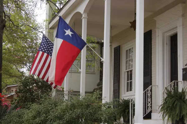 American Flag and Texas Flag fly outside Antebellum Home_436964794