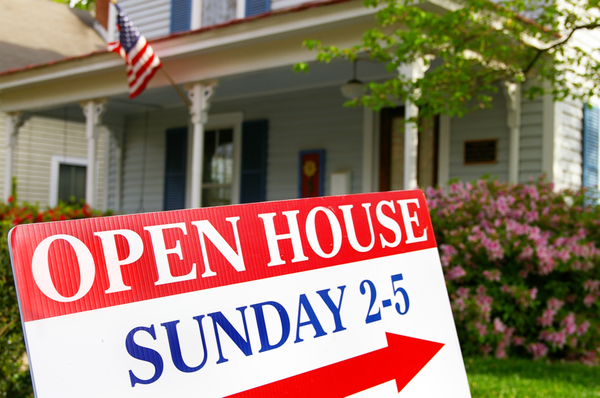 Open house sign pointing to colonial revival style home.