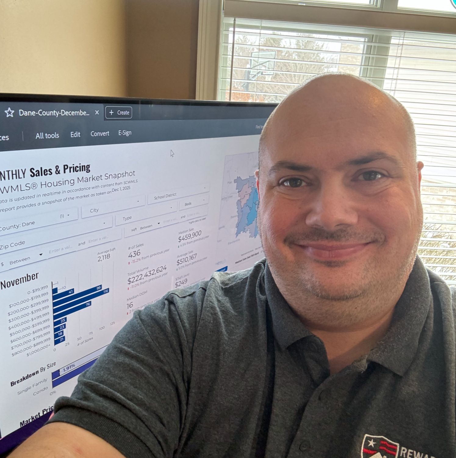 John Reuter reviewing Dane County real estate market data for December 2025 on a large screen.