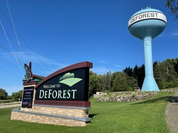 DeForest Wisconsin neighborhood street with mature trees and single-family homes in spring 2026