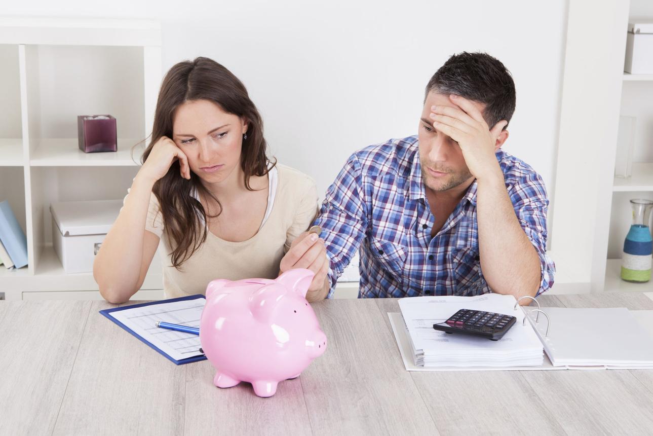 Couple reviewing finances and worrying about saving for a home down payment.