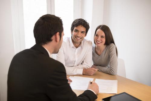 Mortgage lender explaining down payment options to first-time home buyers.