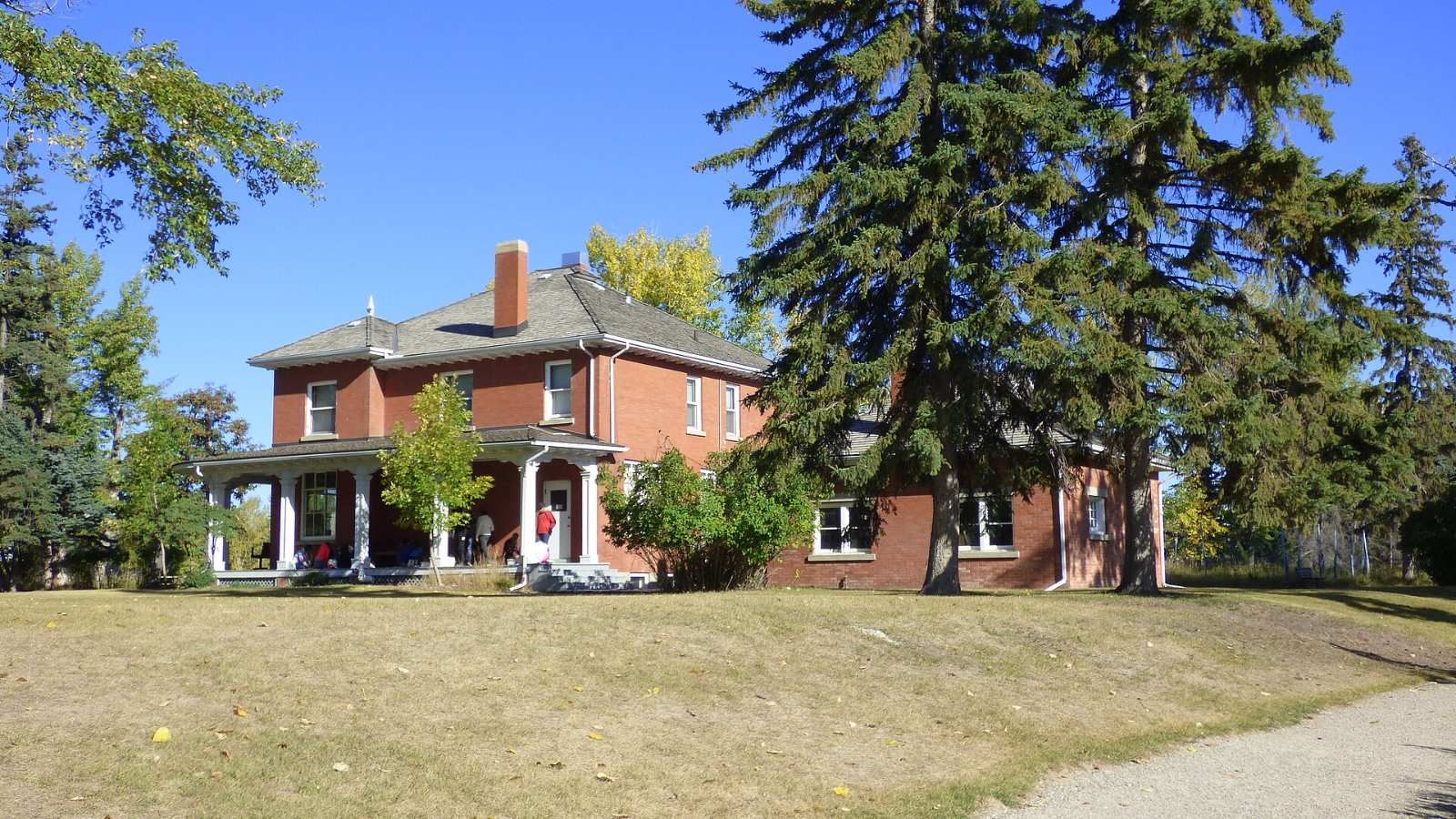 Colonel Walker House, a red-brick heritage home among spruce trees in the Inglewood Bird Sanctuary, Calgary