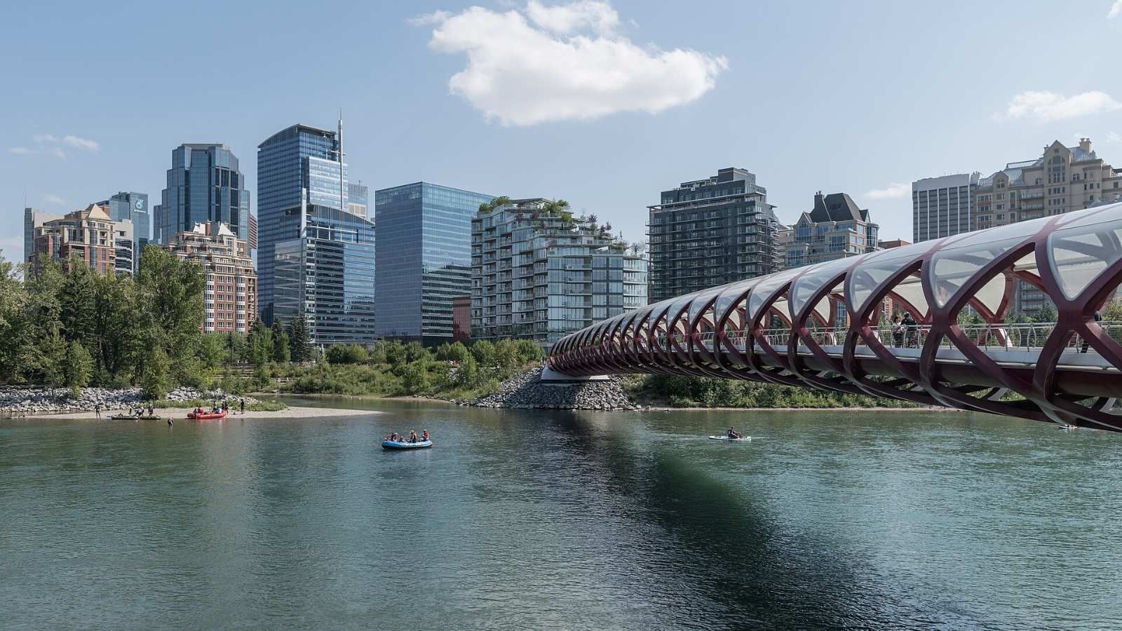 Peace Bridge over the Bow River with the Eau Claire riverfront and downtown towers behind, Calgary