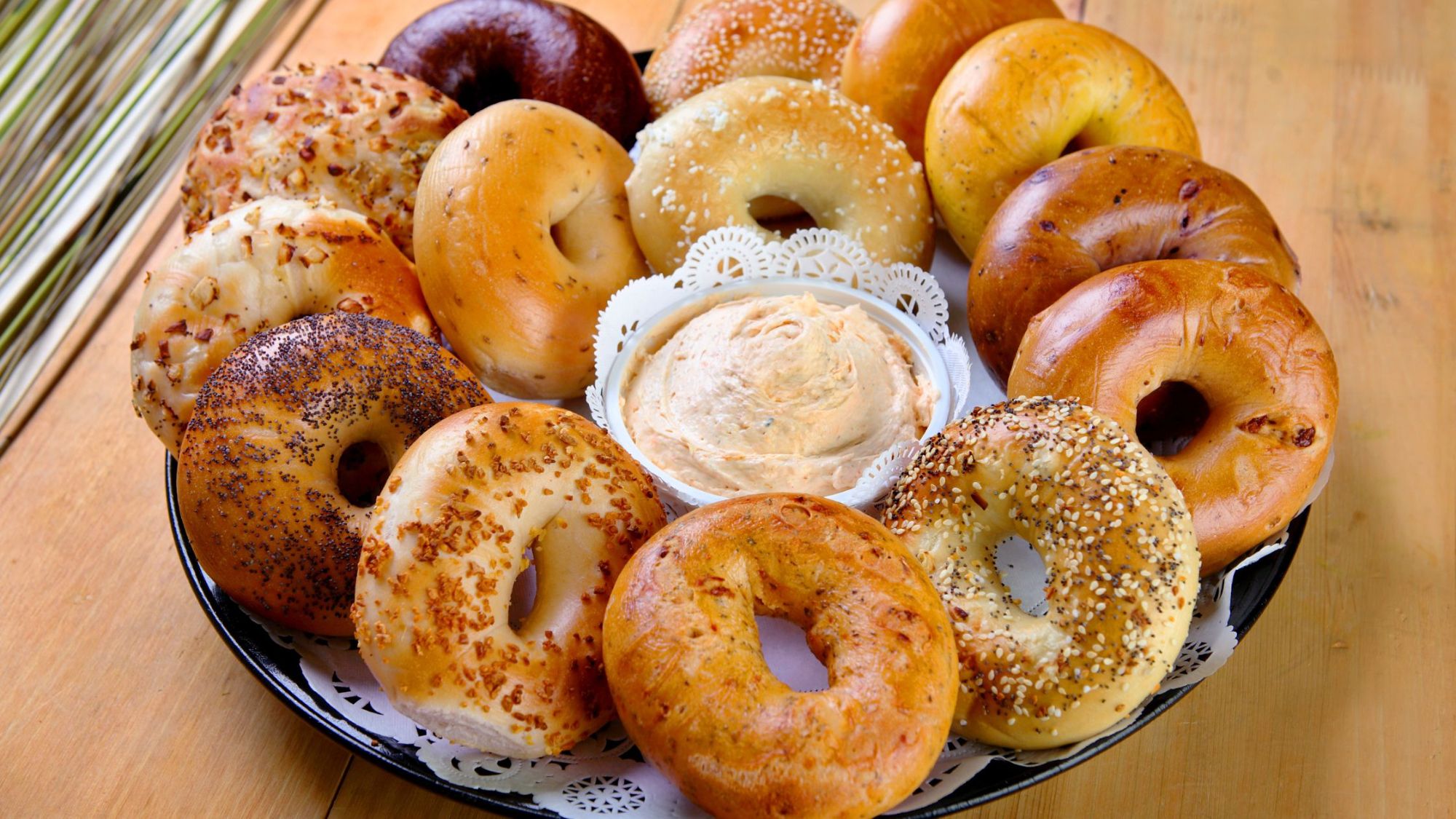 Variety of fresh bagels with cream cheese on serving tray