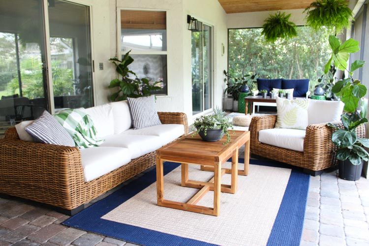 Beautiful outdoor patio with cozy wicker seating, potted plants and warm lighting