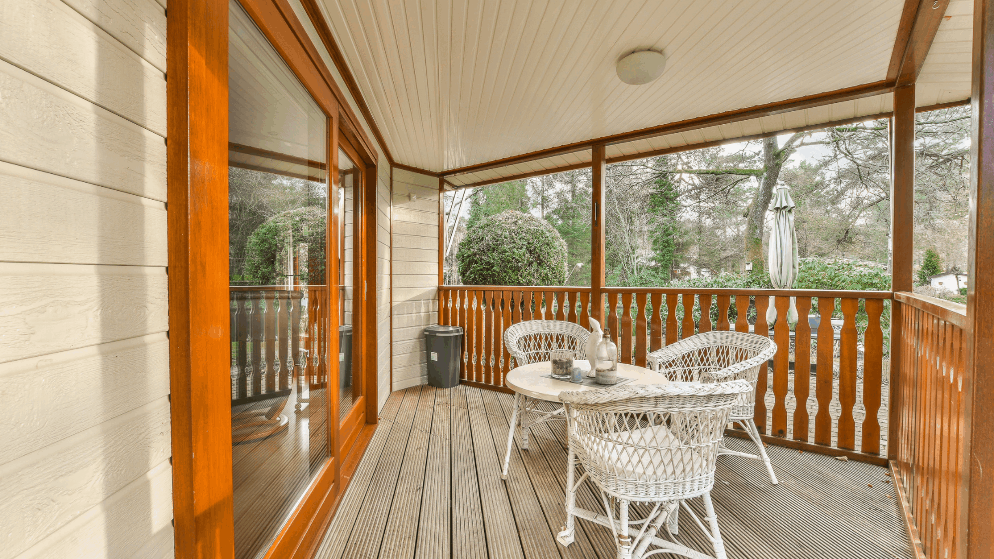 Beautiful covered porch with comfortable outdoor sofa, rugs and warm lighting