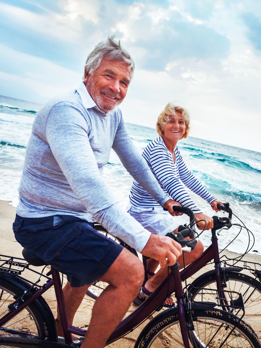 Choosing the Right Manufactured Home Lifestyle with Couple riding bikes at the beach