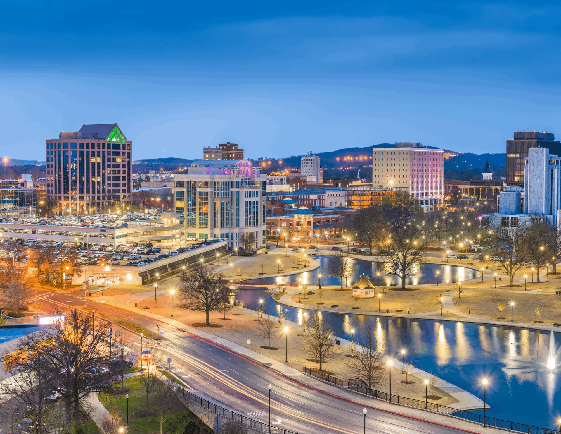 The downtown Huntsville, Alabama skyline at twilight with Big Spring Park reflections and the surrounding hills, captured from above