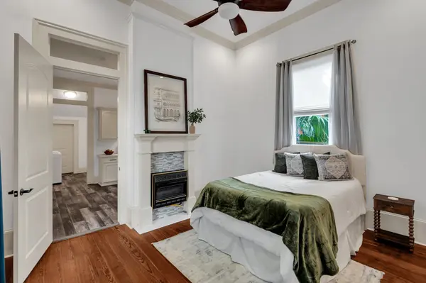 Staged bedroom with fireplace and green velvet throw