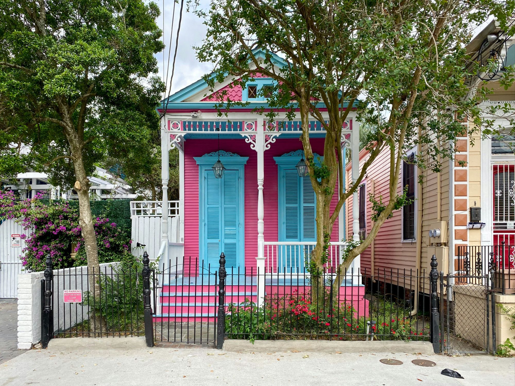 A unique, blue, pink and white NOLA home with a neat front garden.