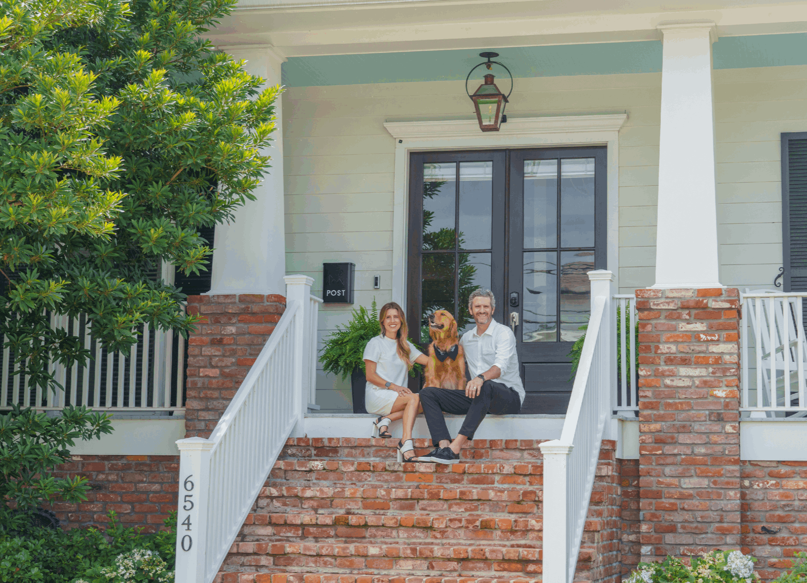 Couple and their dog on the front steps of a New Orleans home