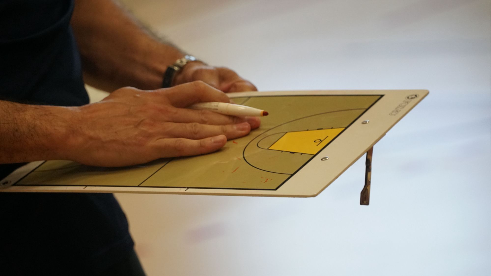 Coach holding a strategy board.