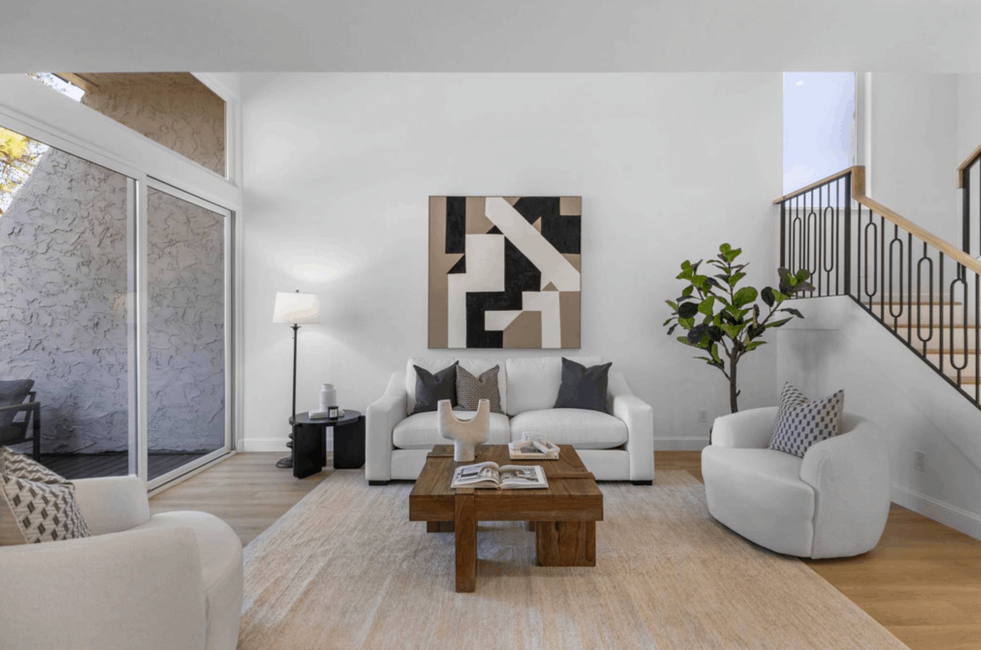Two-story great room with sliding doors and an open stair with an iron railing
