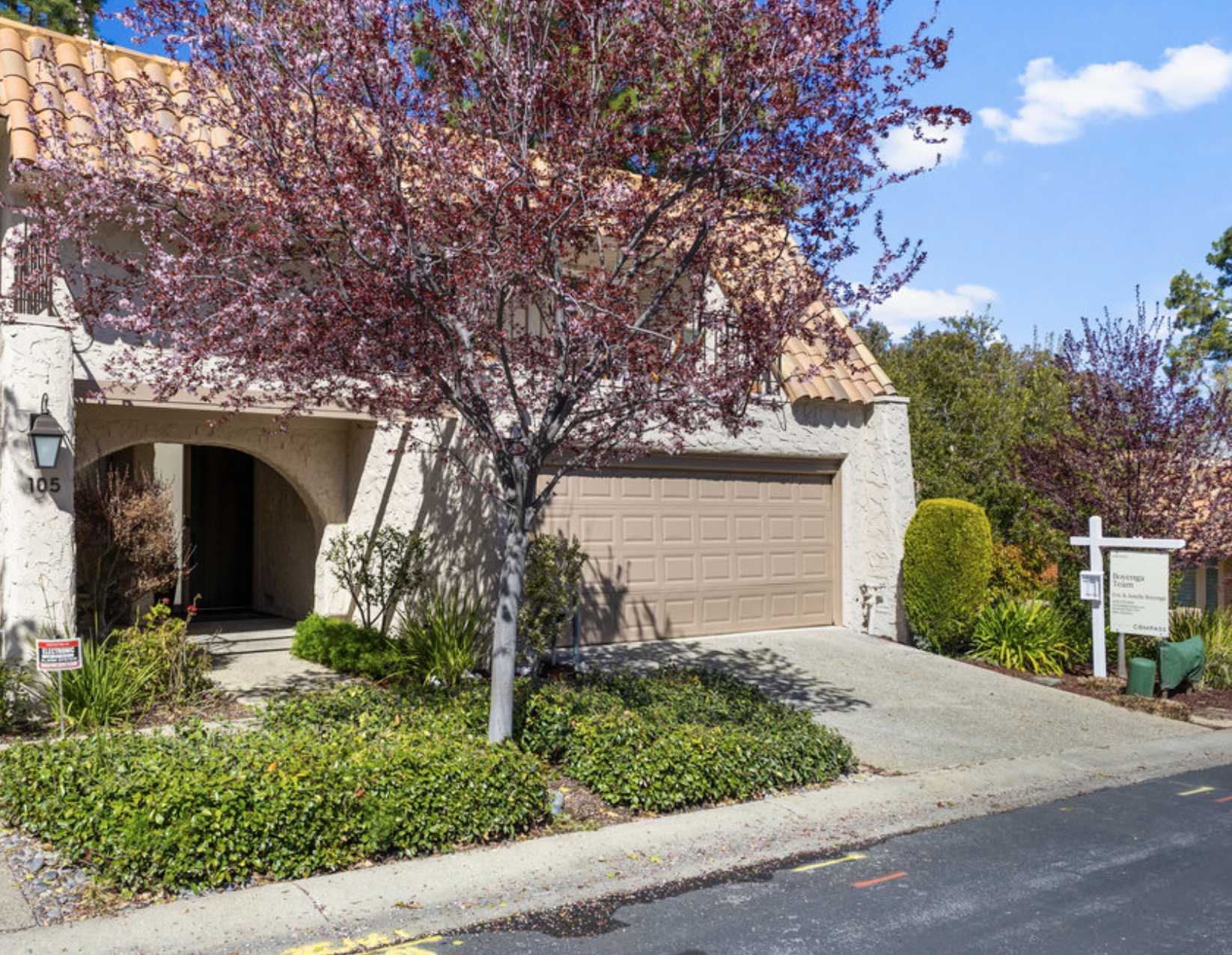 Front of a Rinconada Hills townhome with a tile roof, stucco walls, an arched entry and a garage