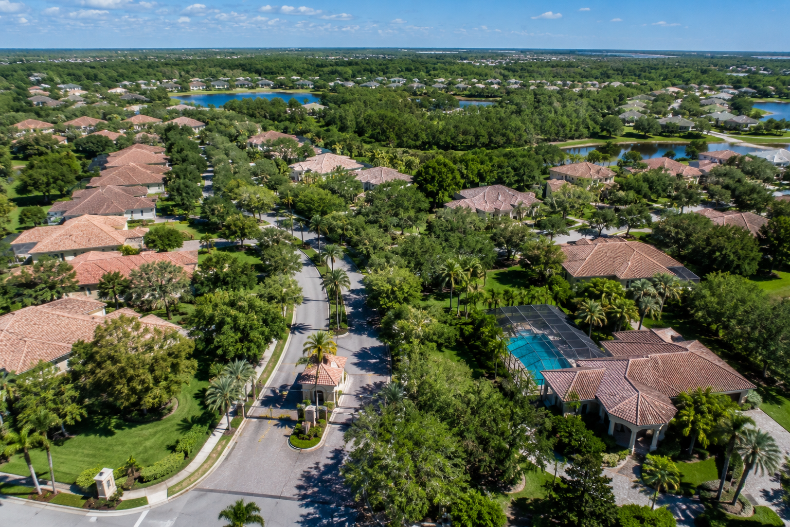 Aerial view of Dr. Phillips Florida residential community showing gated entrance pool area and tree canopy near Sand Lake Road