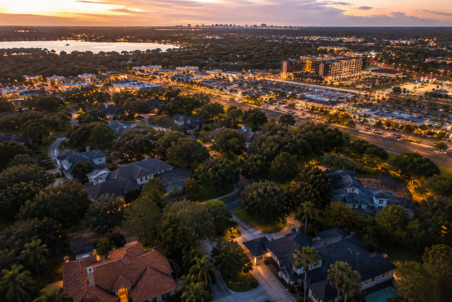 Aerial view comparing established Dr. Phillips estates near Sand Lake Road with new Laureate Park homes in Lake Nona Orlando
