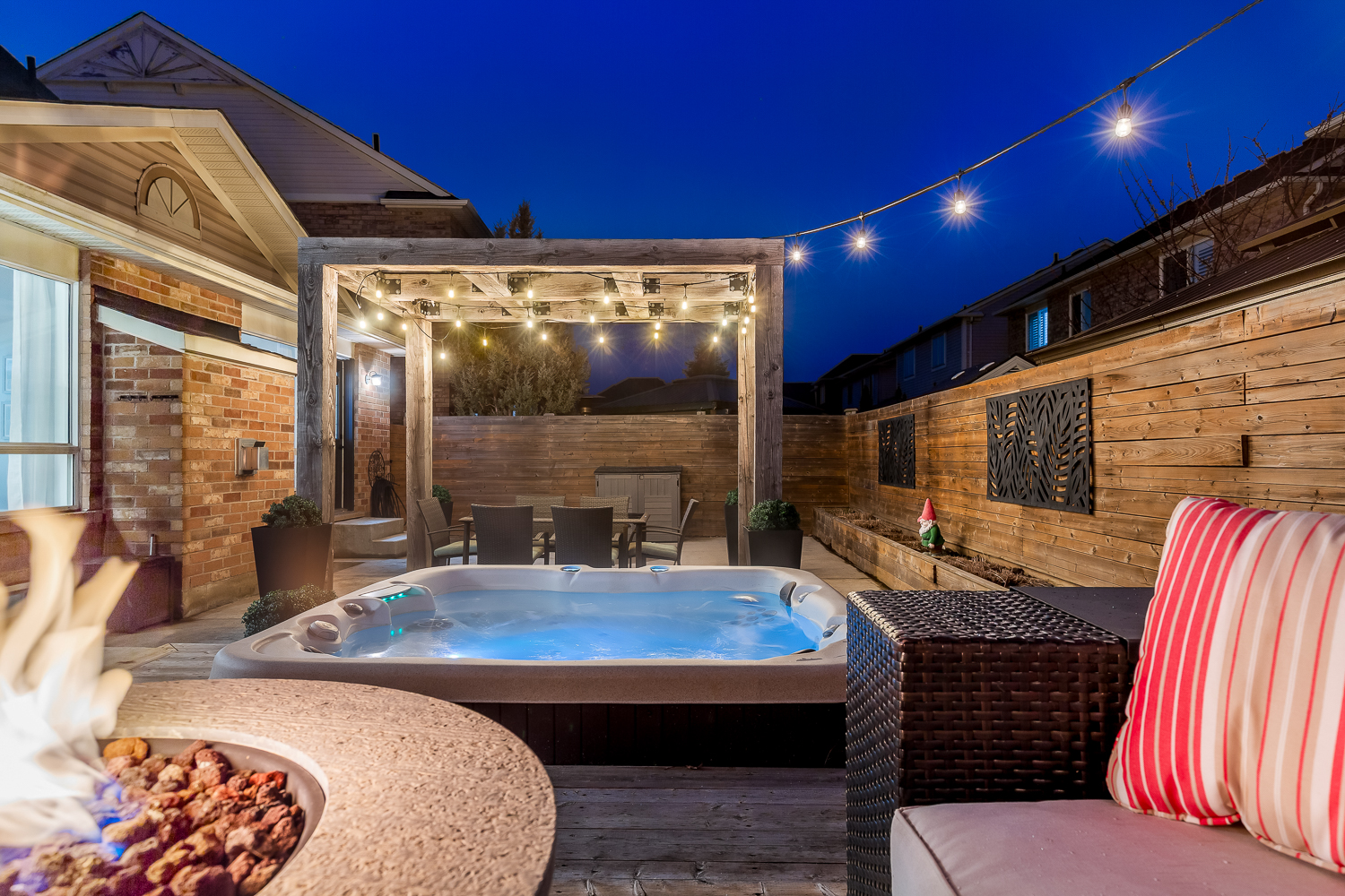 Resort-style backyard at 1537 Morse Place Milton with timber pergola and Edison bulbs at twilight