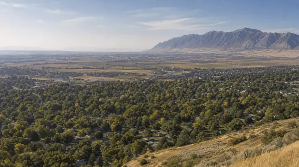 Salt Lake County vs Davis County - elevated view across the Salt Lake Valley toward established neighborhoods, farmland and the Wasatch Range