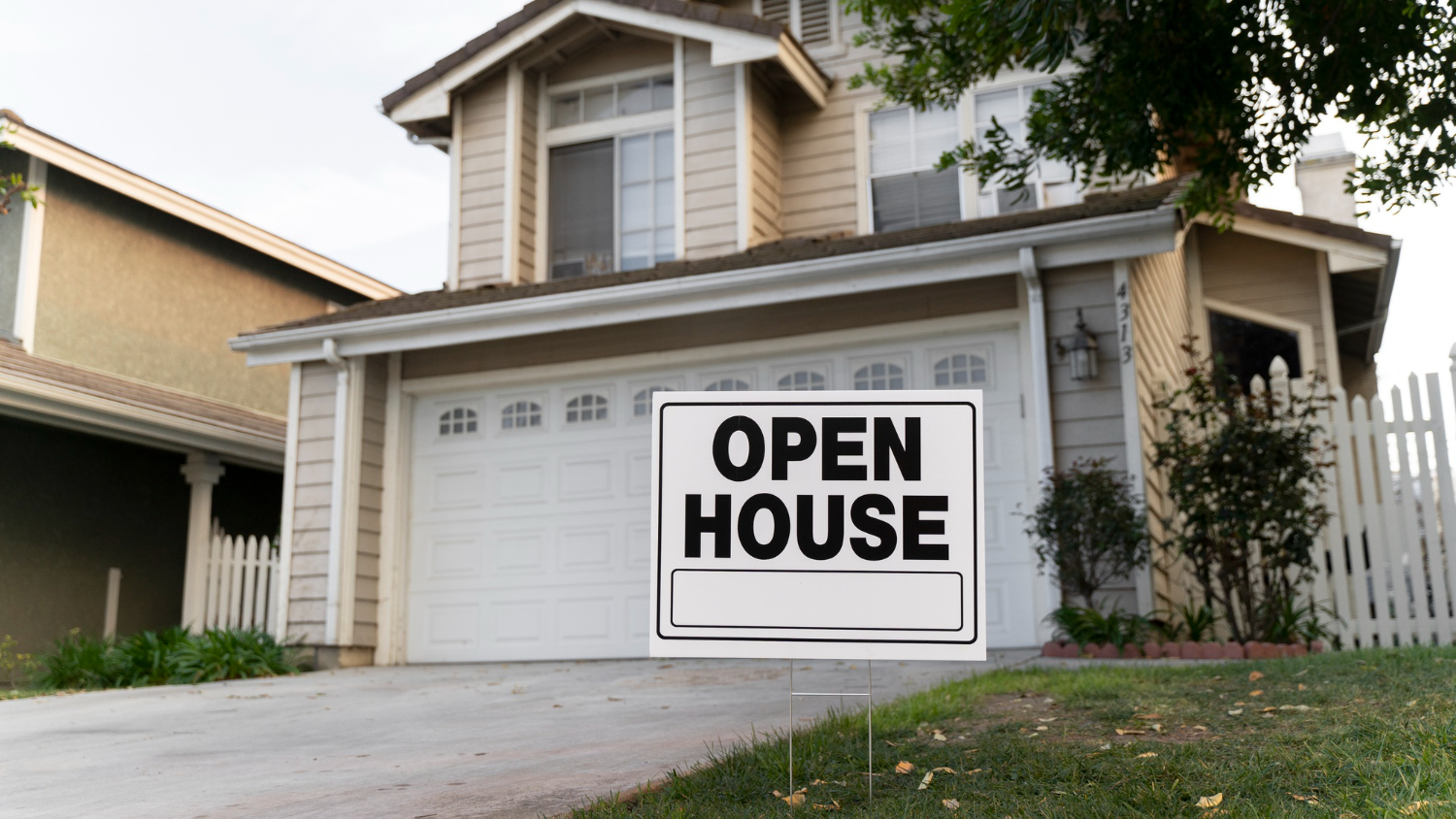 home with open house sign in front of it