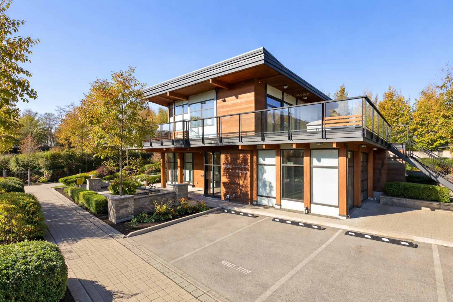 Modern West Coast Club amenities building at Breeze Townhomes by Adera in South Surrey, featuring wood exterior, large windows, upper deck, and landscaped surroundings.