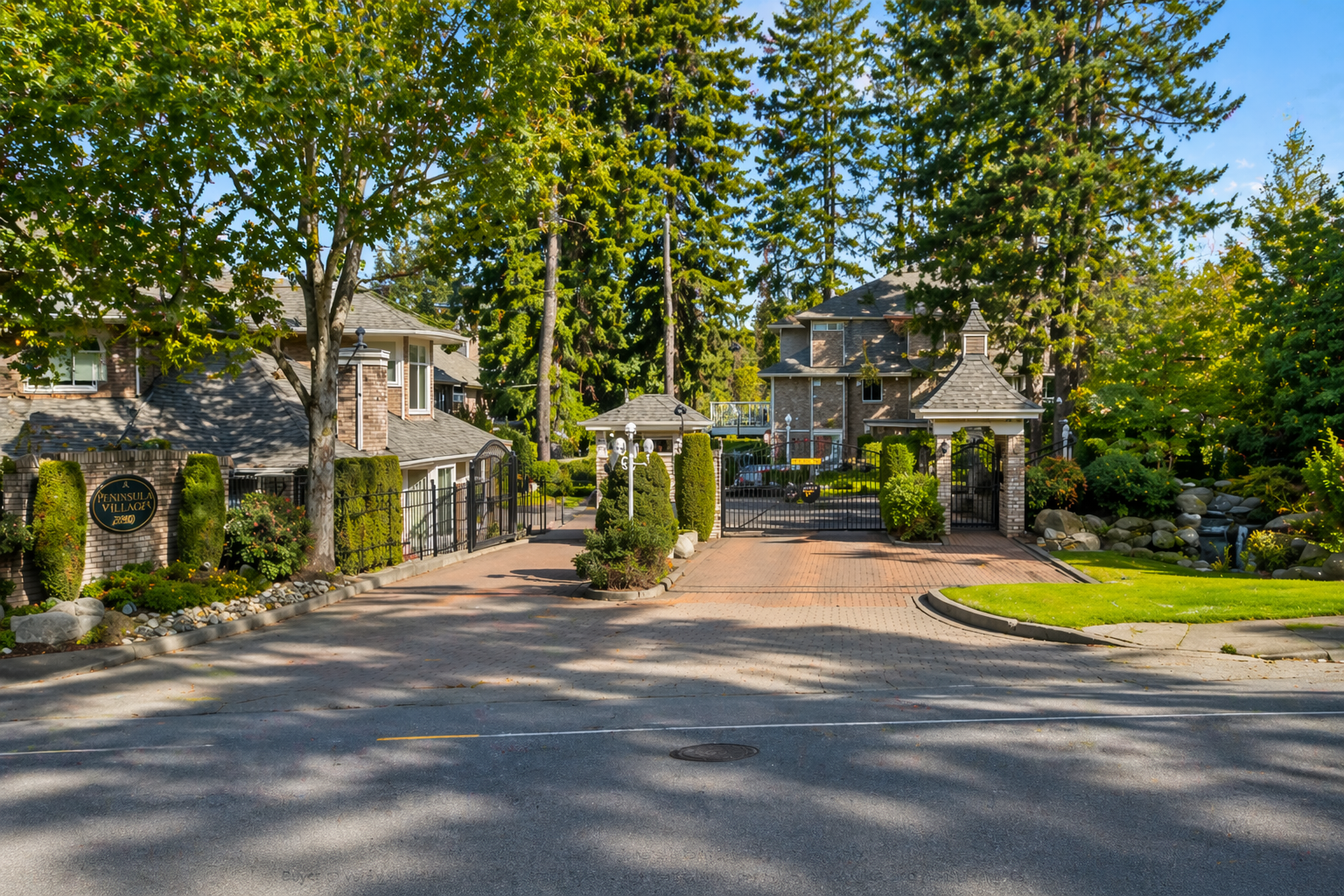 Gated entrance to Peninsula Village townhomes at 2500 152 Street in South Surrey, BC, featuring landscaped grounds, secure access gate, and mature trees in a 55+ community.