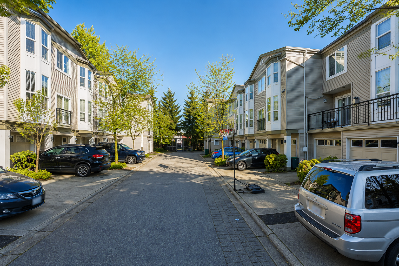 Interior roadway view of Rockland townhomes at 9559 130A Street in Queen Mary Park Surrey BC featuring multi-level townhouse buildings, garage parking, and central community access road