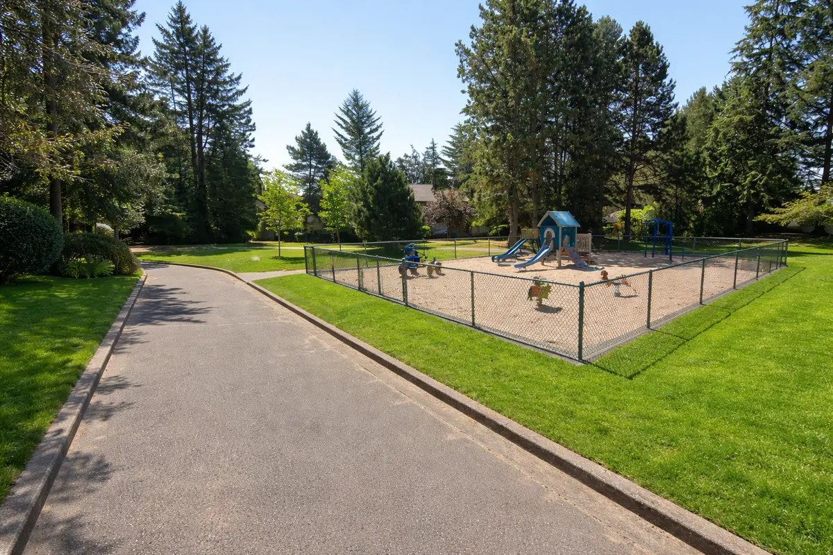 Children’s playground near Alderwood 3 townhomes in South Surrey with green lawn and fenced play area