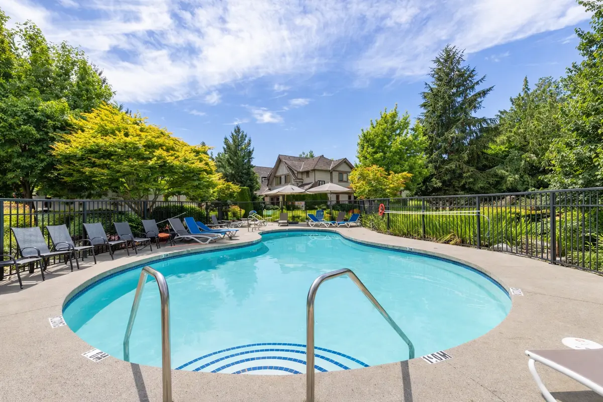 Outdoor pool at Wills Creek townhomes in South Surrey featuring landscaped surroundings, lounge seating, and community amenities in Grandview neighbourhood