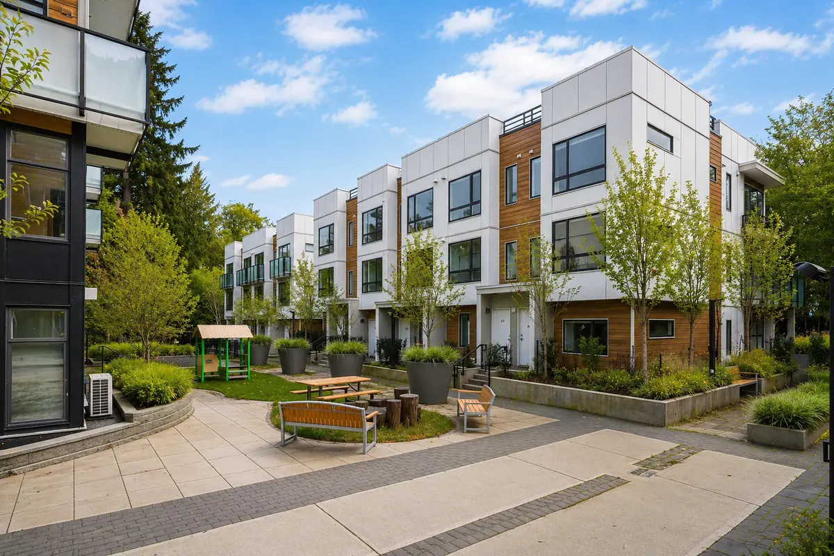 Courtyard view of Creekside Terrace townhomes in Surrey BC showing modern 2026-built buildings, landscaped green space, seating area and shared outdoor amenities