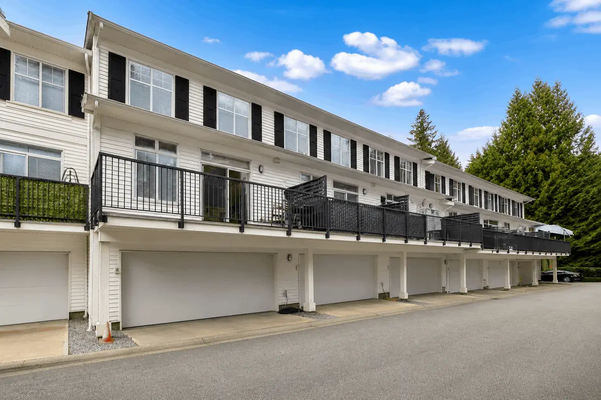 Exterior view of Guildford The Great II townhomes in Surrey BC showing row of garages, upper balconies and modern multi-level townhouse design