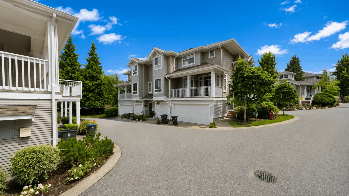 Internal roadway and townhomes at Summer Ridge, located at 15068 58 Avenue in Sullivan Station, Surrey BC, showcasing three-level wood-frame townhomes, attached garages, landscaped grounds and the well-maintained residential community.