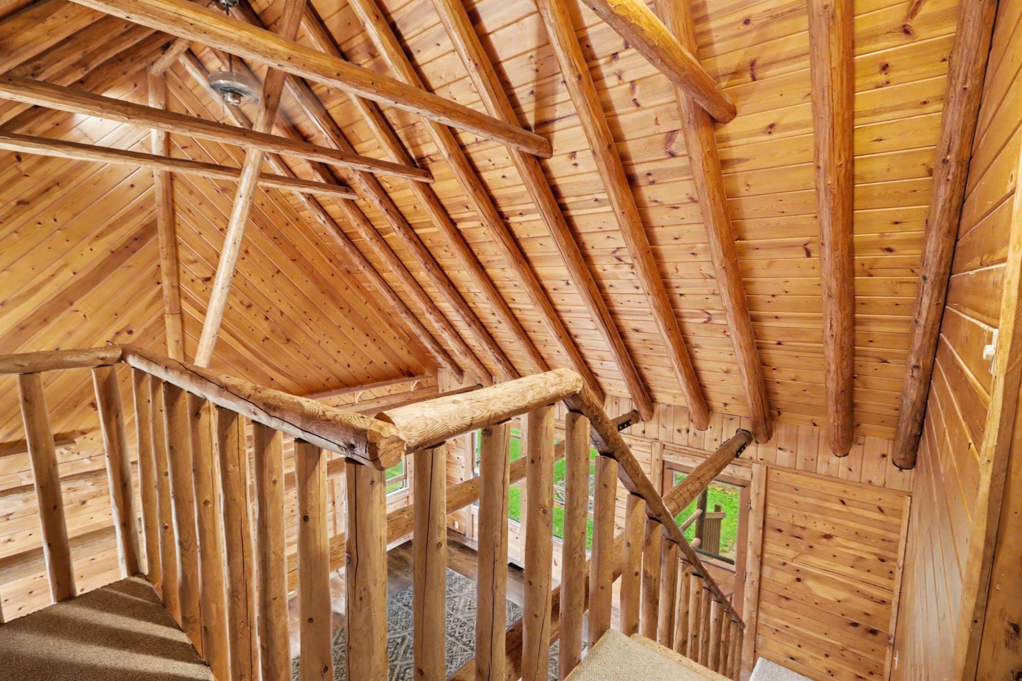 Exposed beam vaulted ceiling and loft in Schoolcraft Michigan log home