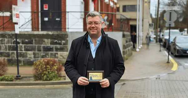 Jason Anson People’s Choice Award Winning REALTOR on Vancouver Island holding community award plaque