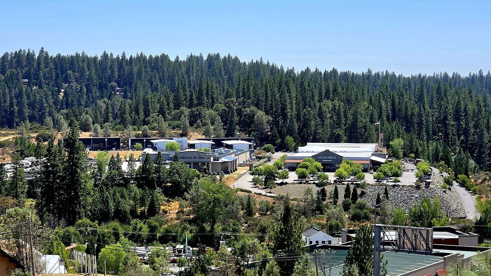 Tall pines covering the hills above homes and buildings in the Hills Flat area of Grass Valley, California