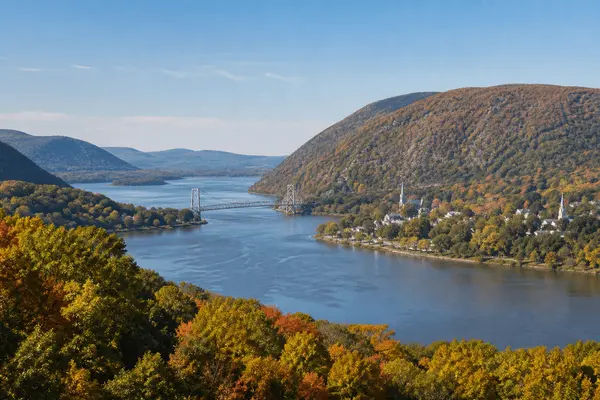 The Hudson River winding between forested ridges in early autumn