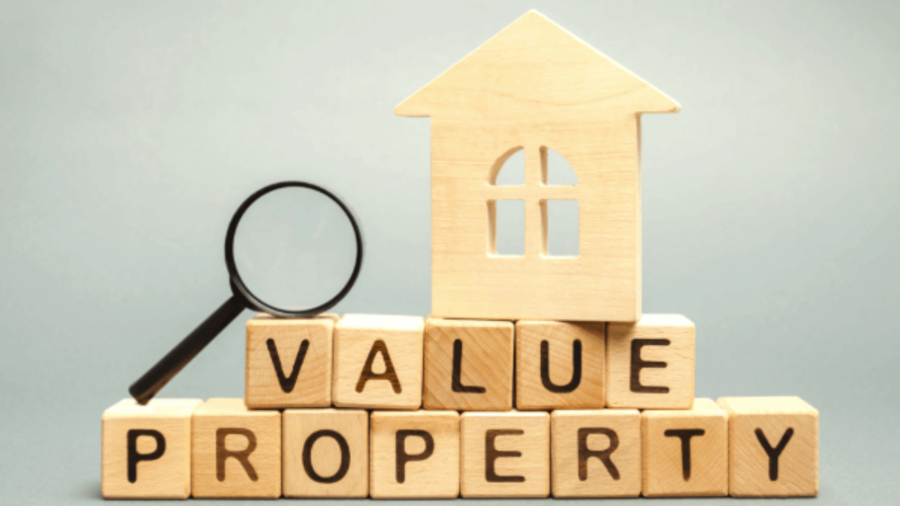 Wooden house, magnifying glass and property value blocks illustrating the importance of strategic home pricing when selling