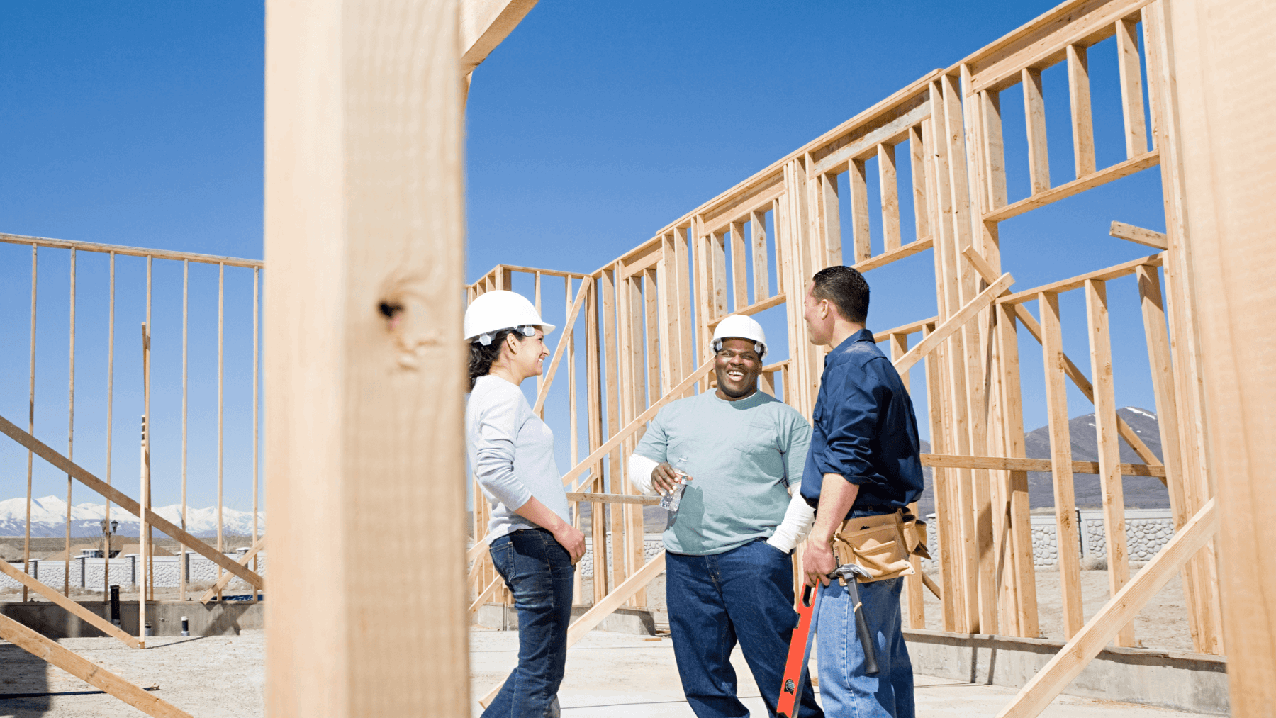 New construction home framing with builders discussing the project, illustrating builder negotiations and incentives for home buyers