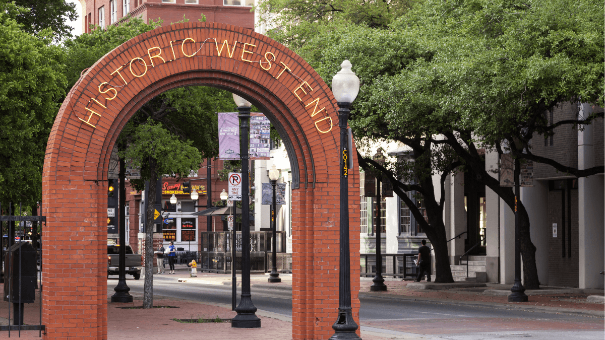 Historic West End entrance arch in downtown Dallas, Texas, highlighting the neighborhood’s brick streets, historic buildings and urban character