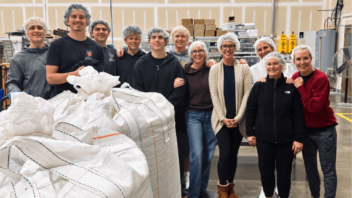 Group of YMSL volunteers in a Dallas-area warehouse supporting local businesses and organizations that give back to the community